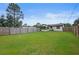Spacious, fenced backyard featuring lush green grass and a covered patio area, ideal for outdoor living at 2415 India Palm Dr, Edgewater, FL 32141