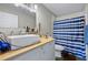 This bathroom features a vessel sink and vanity with a blue and white striped shower curtain at 2415 India Palm Dr, Edgewater, FL 32141