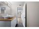 Bathroom with wood-look tile floor, modern vessel sink, wood countertop and neutral walls with an open doorway at 2415 India Palm Dr, Edgewater, FL 32141