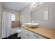 Bright bathroom features a unique vessel sink, wood countertop, tub and shower combination with neutral color scheme at 2415 India Palm Dr, Edgewater, FL 32141