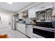 This galley kitchen features stainless steel appliances, grey cabinets, and a patterned backsplash at 2415 India Palm Dr, Edgewater, FL 32141
