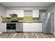 Bright kitchen featuring stainless steel appliances, white cabinets and modern backsplash at 2415 India Palm Dr, Edgewater, FL 32141