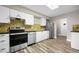 Modern kitchen with stainless steel appliances, white cabinets, and tile backsplash at 2415 India Palm Dr, Edgewater, FL 32141