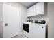 This laundry room features white appliances and overhead cabinets for plenty of storage at 2415 India Palm Dr, Edgewater, FL 32141