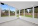 Screened porch with white frame, concrete floors, view of fenced in yard and trees at 2415 India Palm Dr, Edgewater, FL 32141