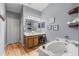 Bathroom with vanity, soaking tub, and decorative shelves with framed art at 2479 Vaughn Ave, Deltona, FL 32725
