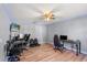Spacious bedroom featuring wood floors, a ceiling fan, and a gaming setup with multiple monitors and gaming chairs at 2479 Vaughn Ave, Deltona, FL 32725