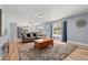 Cozy living room with wood floors, a comfortable couch, and natural light from a large window at 2479 Vaughn Ave, Deltona, FL 32725