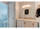 Bathroom featuring a white cabinet with a marble countertop, gold accents, and an updated light fixture at 28 River Dr, Ormond Beach, FL 32176