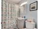 Bathroom featuring a gray cabinet, modern sink, and nautical-themed shower curtain at 28 River Dr, Ormond Beach, FL 32176