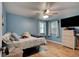 Bedroom featuring a ceiling fan, wood-look tile, light-blue walls, and two large windows for natural light at 28 River Dr, Ormond Beach, FL 32176