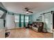 Cozy living room featuring wood-look flooring, a ceiling fan, and comfortable leather sofa at 28 River Dr, Ormond Beach, FL 32176