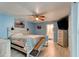 Bedroom features a ceiling fan and light-blue walls with access to an en-suite bathroom, all resting on light-colored wood-look tile at 28 River Dr, Ormond Beach, FL 32176