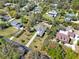 This aerial view displays a neighborhood with homes featuring expansive yards, mature trees, and unique architectural styles at 29127 Old E Ml, Tavares, FL 32778