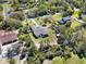This aerial view displays a neighborhood with homes featuring expansive yards, mature trees, and unique architectural styles at 29127 Old E Ml, Tavares, FL 32778