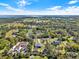 This aerial view displays a neighborhood with homes featuring expansive yards, mature trees, and unique architectural styles at 29127 Old E Ml, Tavares, FL 32778