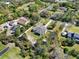 This aerial view displays a neighborhood with homes featuring expansive yards, mature trees, and unique architectural styles at 29127 Old E Ml, Tavares, FL 32778