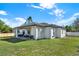 Rear view of the home with a covered patio and well-manicured lawn at 29127 Old E Ml, Tavares, FL 32778