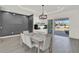 Dining area with modern chandelier, gray accent wall, and sliding glass doors leading to the patio at 29127 Old E Ml, Tavares, FL 32778