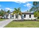 Charming single-story home features lush green lawn, palm tree, and patterned paver driveway at 29127 Old E Ml, Tavares, FL 32778