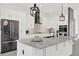 Modern white kitchen featuring marble counters, stainless steel appliances, and pendant lighting at 29127 Old E Ml, Tavares, FL 32778