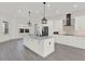 Open-concept kitchen with white cabinets, an island with marble counters, and stainless steel appliances at 29127 Old E Ml, Tavares, FL 32778