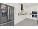Spacious kitchen with stainless steel refrigerator, white cabinets, and grey tile flooring at 29127 Old E Ml, Tavares, FL 32778