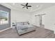 Spacious main bedroom with tray ceiling, ceiling fan, and sliding barn door to bathroom at 29127 Old E Ml, Tavares, FL 32778