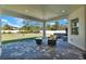 Covered outdoor patio with stone pavers and seating area overlooking the yard at 29127 Old E Ml, Tavares, FL 32778