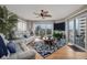 Well-lit living room with sliding glass doors to a balcony, large screen TV, and ceiling fan at 2967 S Atlantic Ave # 301, Daytona Beach Shores, FL 32118