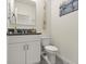 Powder room with white cabinet, granite countertop, mirror and toilet at 3075 Meleto Blvd, New Smyrna Beach, FL 32168
