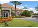 Exterior view of the Venetian Bay clubhouse, featuring lush landscaping and golf cart parking at 3075 Meleto Blvd, New Smyrna Beach, FL 32168