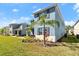 A bright blue two-story home with a manicured lawn and tropical landscaping featuring a young palm tree at 3075 Meleto Blvd, New Smyrna Beach, FL 32168