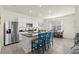 A well-lit kitchen features white cabinets, stainless appliances, a granite island with barstool seating, and tile flooring at 3075 Meleto Blvd, New Smyrna Beach, FL 32168