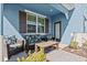 Covered patio with two seats, table, brown shutters and blue walls at 3075 Meleto Blvd, New Smyrna Beach, FL 32168