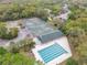 Aerial view showcasing the community pool, tennis courts, clubhouse, and lush green surroundings at 3145 Connemara Dr, Ormond Beach, FL 32174