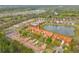 Aerial view of a community with lush landscaping, a scenic pond, and well-maintained homes with red roofs at 3145 Connemara Dr, Ormond Beach, FL 32174