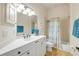 Bright bathroom featuring a white vanity, neutral tile flooring, and a shower-tub combo with patterned curtain at 3145 Connemara Dr, Ormond Beach, FL 32174
