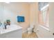 Cozy half bathroom featuring tiled floors, a white toilet and vanity, and a window at 3145 Connemara Dr, Ormond Beach, FL 32174