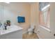 Powder room features a white vanity with sink, toilet, and window with curtains at 3145 Connemara Dr, Ormond Beach, FL 32174