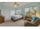 Cozy bedroom featuring two large windows, ceiling fan and recliner at 3145 Connemara Dr, Ormond Beach, FL 32174