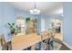 Dining area leading to the kitchen, featuring wood table with blue chairs, wooden china cabinet, and neutral blue color scheme at 3145 Connemara Dr, Ormond Beach, FL 32174
