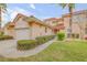 Charming home featuring a red tile roof, arched entry, manicured landscaping, and attached two-car garage at 3145 Connemara Dr, Ormond Beach, FL 32174