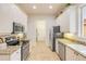 Well-lit kitchen featuring stainless appliances, granite countertops and white cabinets, with door to laundry room at 3145 Connemara Dr, Ormond Beach, FL 32174