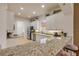 Bright kitchen features white cabinets, granite countertops, stainless steel appliances, and a view of the laundry room at 3145 Connemara Dr, Ormond Beach, FL 32174
