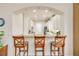 Bright kitchen featuring granite countertops, white cabinetry and a breakfast bar with seating for three at 3145 Connemara Dr, Ormond Beach, FL 32174