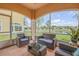 Screened lanai featuring comfortable wicker furniture and views of the lush backyard and serene lake at 3145 Connemara Dr, Ormond Beach, FL 32174
