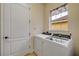 Bright laundry room with side-by-side washer and dryer beneath window with decorative valance at 3145 Connemara Dr, Ormond Beach, FL 32174