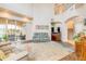 Bright living room featuring high ceilings, tan leather furniture, sliding glass doors to patio, and staircase to loft at 3145 Connemara Dr, Ormond Beach, FL 32174