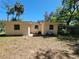 A view of the property's backyard showing an exterior elevation of the home with windows and utilities at 318 S Massachusetts Ave, Deland, FL 32724